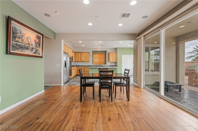 dining room with recessed lighting, visible vents, light wood-style flooring, and baseboards