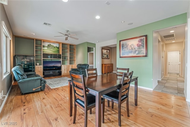 dining area with light wood-type flooring, visible vents, and a ceiling fan