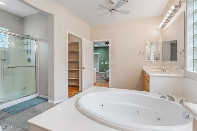 ensuite bathroom featuring vanity, a shower stall, a jetted tub, and ceiling fan