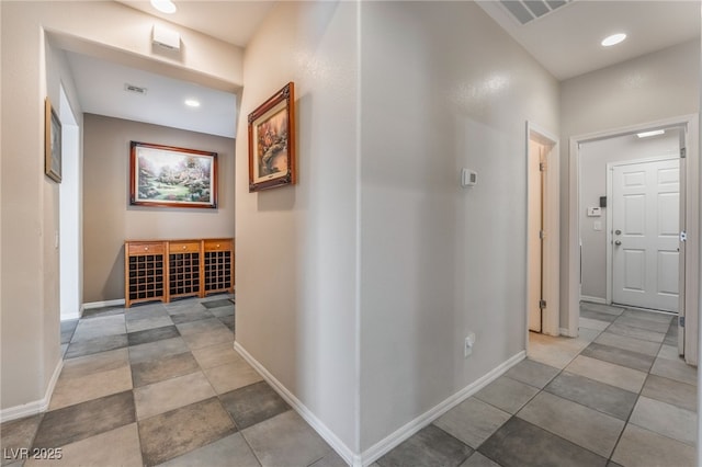 hall with recessed lighting, visible vents, and baseboards