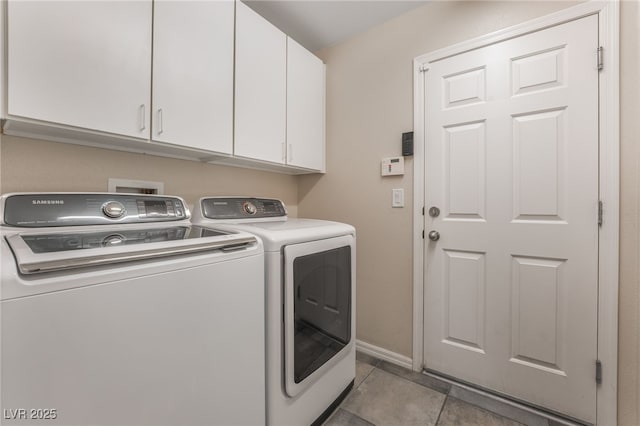 washroom with light tile patterned flooring, cabinet space, baseboards, and washing machine and clothes dryer