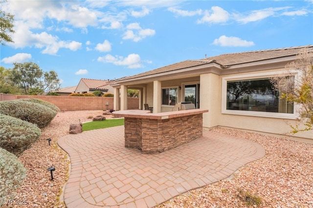 view of patio / terrace featuring exterior kitchen and fence