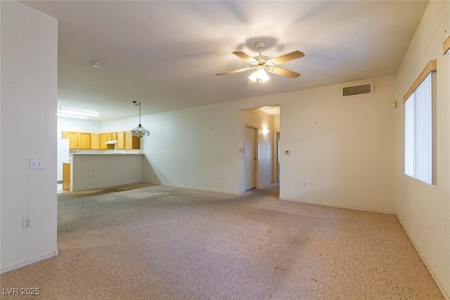 unfurnished living room with visible vents and ceiling fan