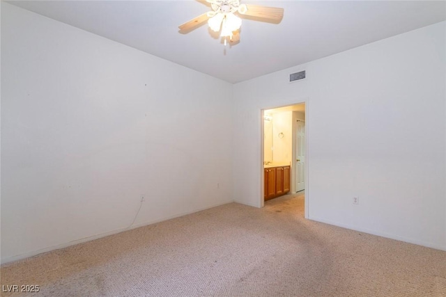 spare room featuring visible vents, light colored carpet, baseboards, and ceiling fan