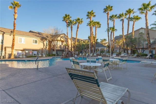 pool featuring a patio, fence, and a residential view