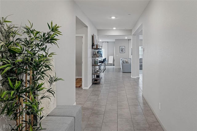 hallway with light tile patterned floors, recessed lighting, and baseboards