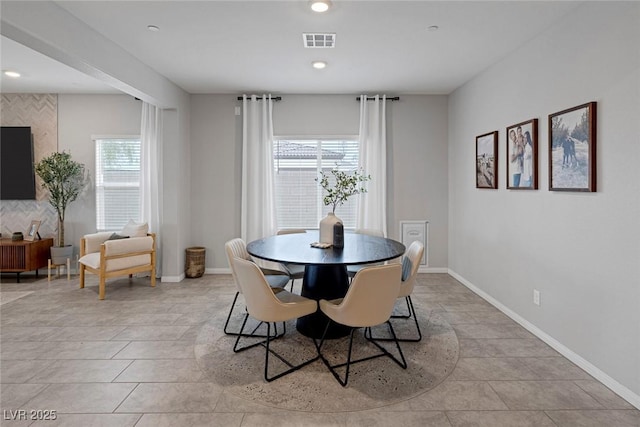 dining space featuring light tile patterned floors, baseboards, and visible vents