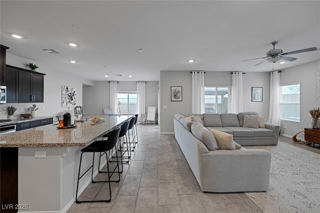 living area with recessed lighting, visible vents, plenty of natural light, and a ceiling fan