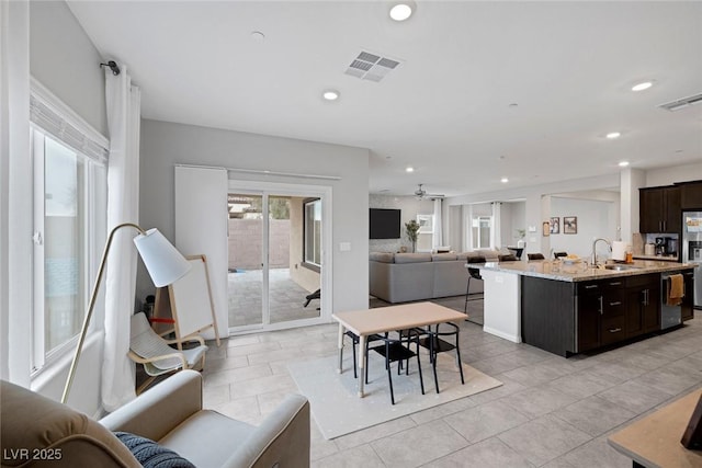 interior space featuring visible vents, dishwashing machine, open floor plan, and a sink