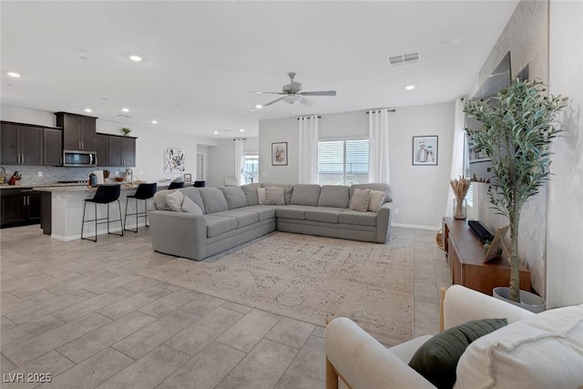 living area with baseboards, recessed lighting, visible vents, and ceiling fan