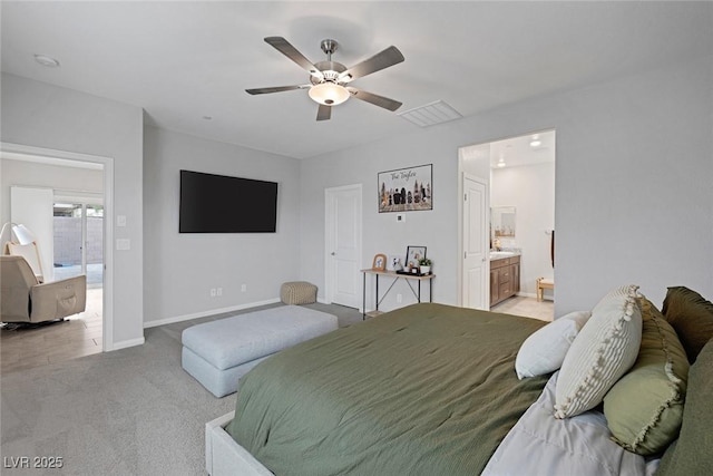 bedroom featuring baseboards, light carpet, ensuite bath, and a ceiling fan