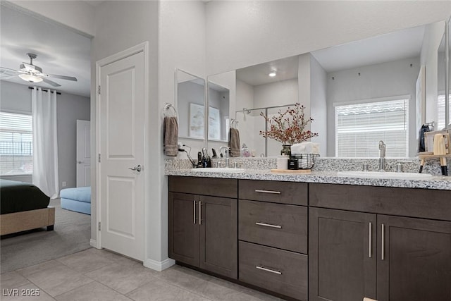 full bathroom with a sink, double vanity, ensuite bath, and a ceiling fan