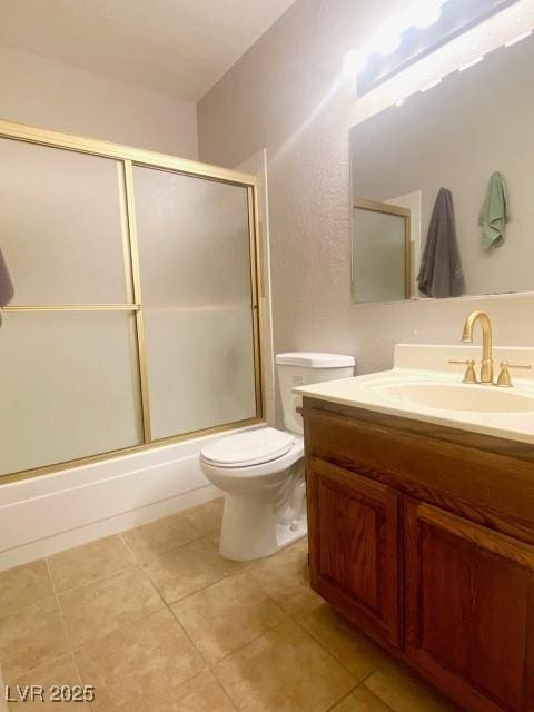 bathroom with toilet, vanity, and tile patterned flooring