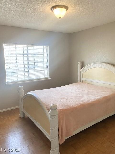 bedroom featuring baseboards and a textured ceiling