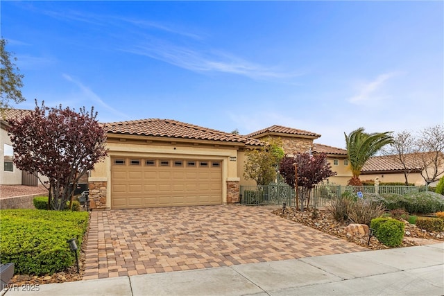 view of front of home featuring decorative driveway, stone siding, and stucco siding