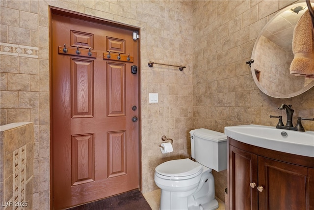 half bathroom featuring toilet, tile walls, and vanity