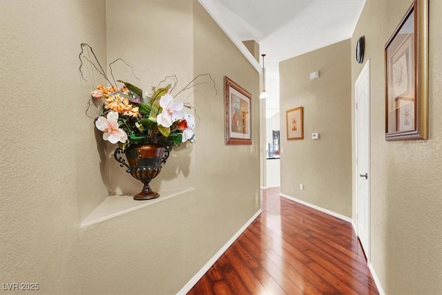 corridor with dark wood-type flooring and baseboards