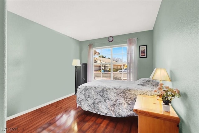 bedroom with baseboards and wood finished floors