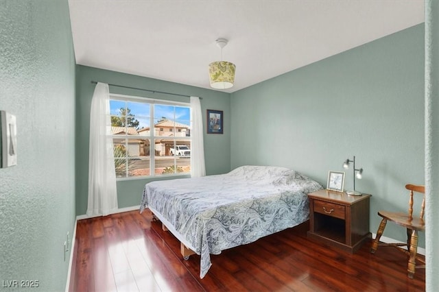 bedroom featuring baseboards and wood finished floors