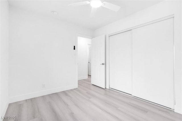 unfurnished bedroom featuring a ceiling fan, wood finished floors, baseboards, and a closet