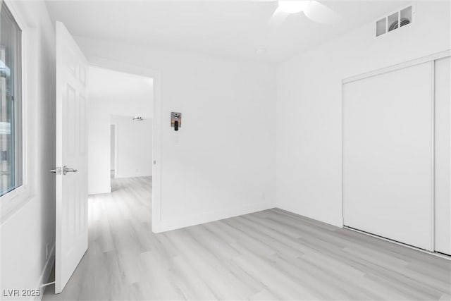 spare room featuring visible vents, baseboards, a ceiling fan, and light wood finished floors