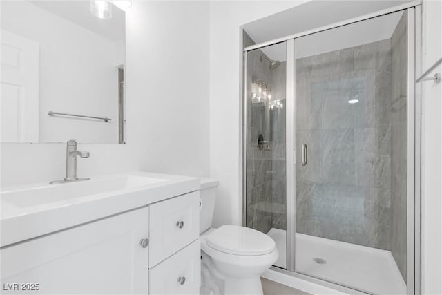 bathroom with vanity, toilet, and a shower stall