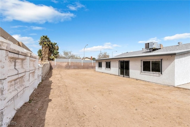 view of yard with central AC unit and a fenced backyard