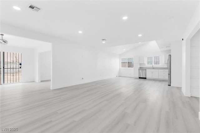 unfurnished living room with light wood-style flooring, plenty of natural light, recessed lighting, and visible vents