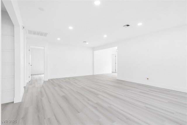 spare room featuring light wood finished floors, visible vents, and recessed lighting