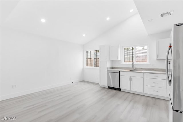 kitchen featuring visible vents, light countertops, stainless steel appliances, white cabinetry, and a sink