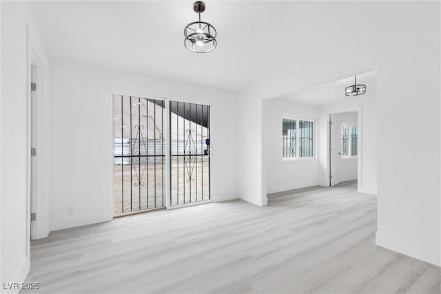 unfurnished room featuring baseboards and wood finished floors