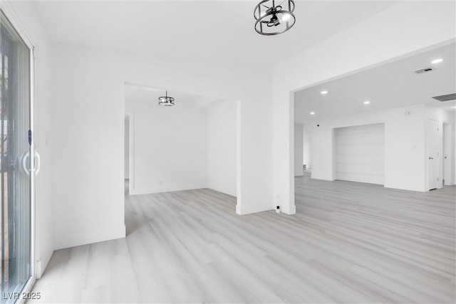 empty room featuring a notable chandelier, recessed lighting, visible vents, and light wood-type flooring