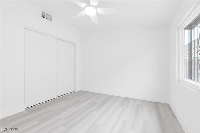 empty room featuring visible vents, ceiling fan, baseboards, and light wood-style floors