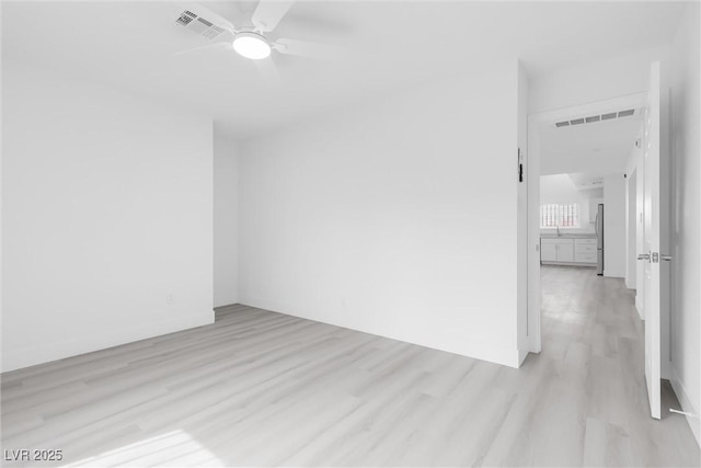 unfurnished room with visible vents, light wood-style floors, and ceiling fan