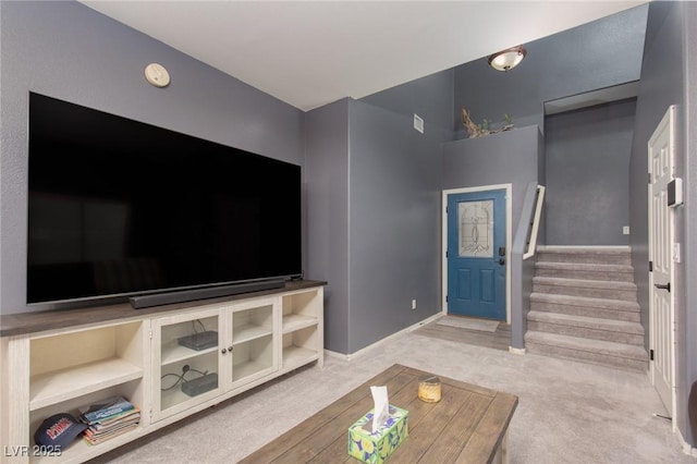 carpeted living area with stairway and baseboards