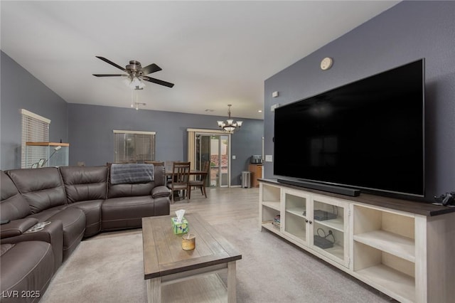 living area featuring ceiling fan with notable chandelier