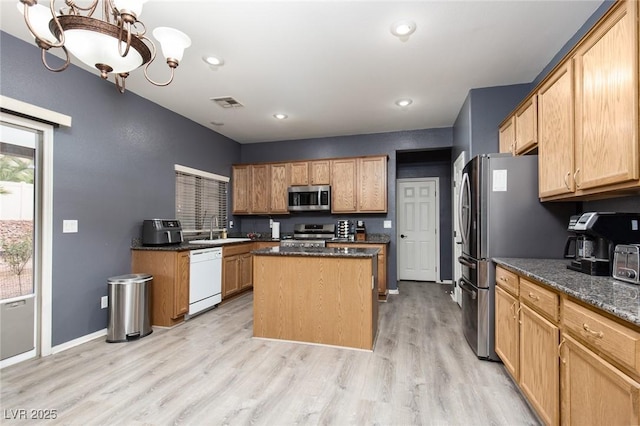 kitchen featuring visible vents, a center island, light wood-style flooring, an inviting chandelier, and stainless steel appliances