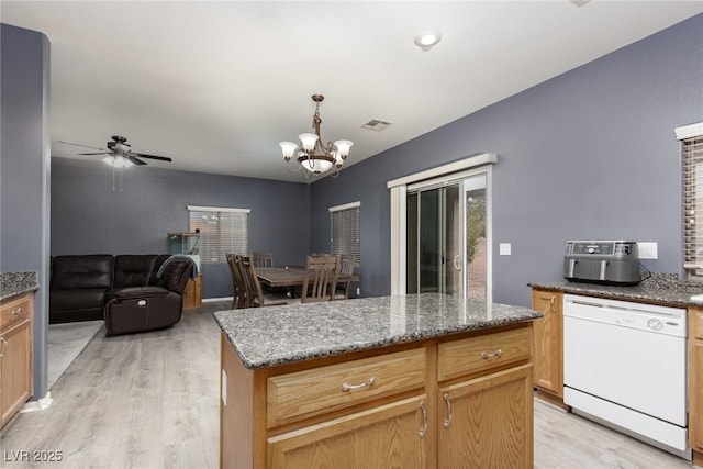 kitchen with dark stone countertops, ceiling fan with notable chandelier, light wood-type flooring, and white dishwasher