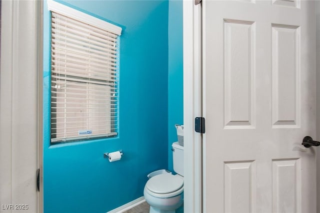 bathroom with toilet and baseboards