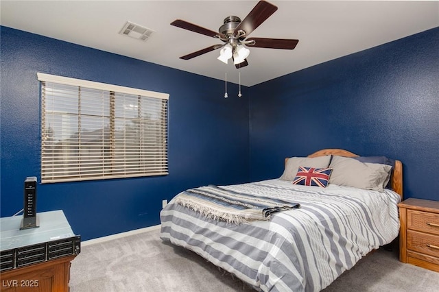 carpeted bedroom featuring baseboards, visible vents, and ceiling fan