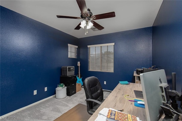 carpeted home office featuring a ceiling fan and baseboards