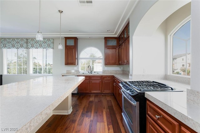 kitchen featuring visible vents, glass insert cabinets, gas range, hanging light fixtures, and dark wood-style flooring