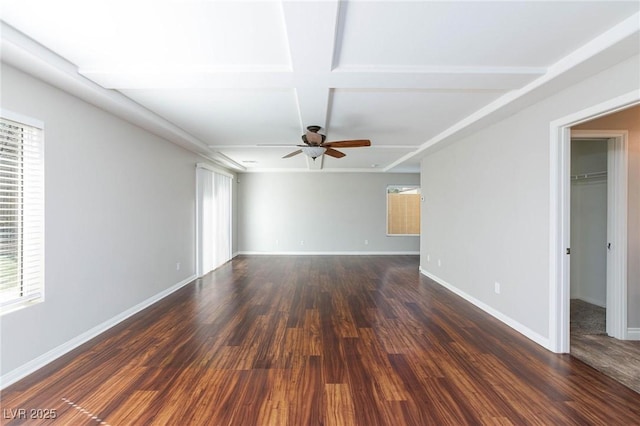 empty room with dark wood finished floors, a ceiling fan, and baseboards