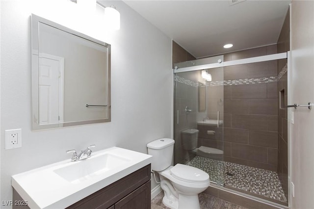 bathroom with vanity, toilet, and a stall shower