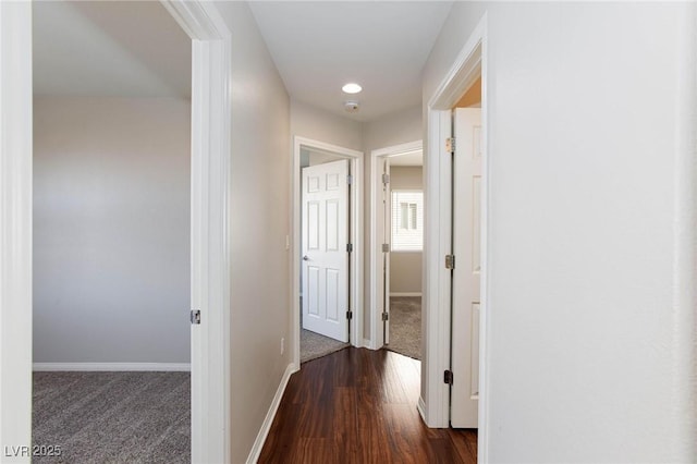 hallway featuring recessed lighting, baseboards, dark wood finished floors, and dark carpet