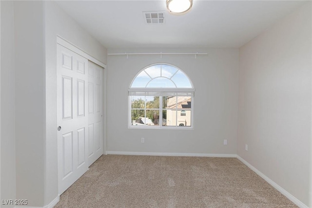 spare room with visible vents, baseboards, and carpet