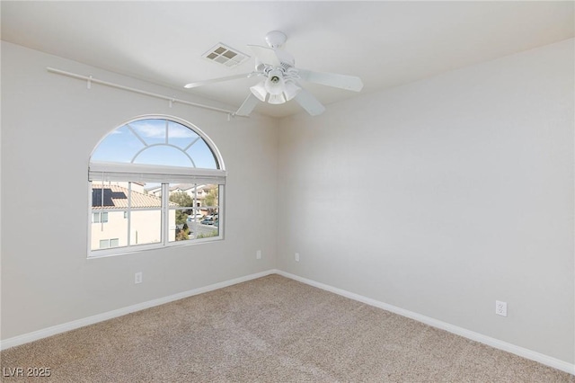 unfurnished room featuring visible vents, carpet floors, baseboards, and a ceiling fan