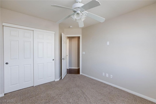 unfurnished bedroom featuring a closet, a ceiling fan, baseboards, and carpet floors