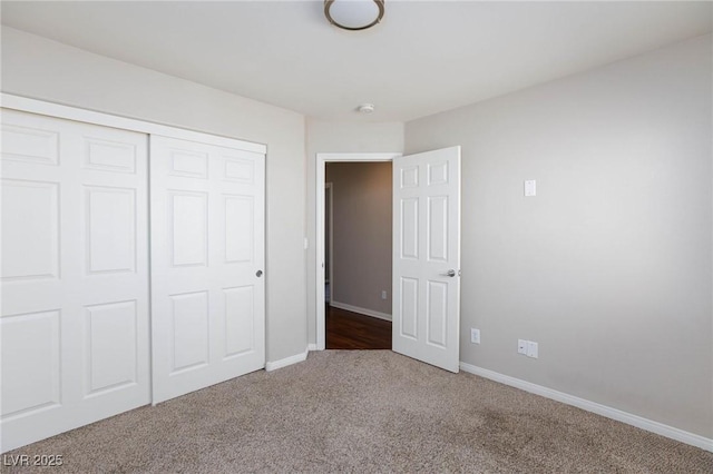 unfurnished bedroom with a closet, baseboards, and carpet