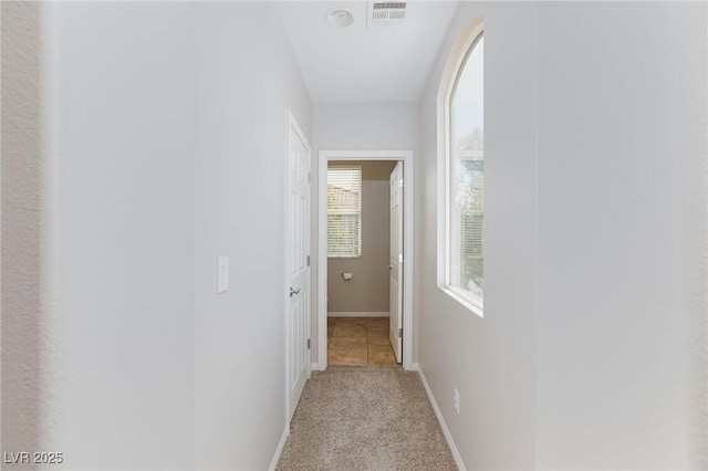 hall featuring carpet flooring, baseboards, and visible vents